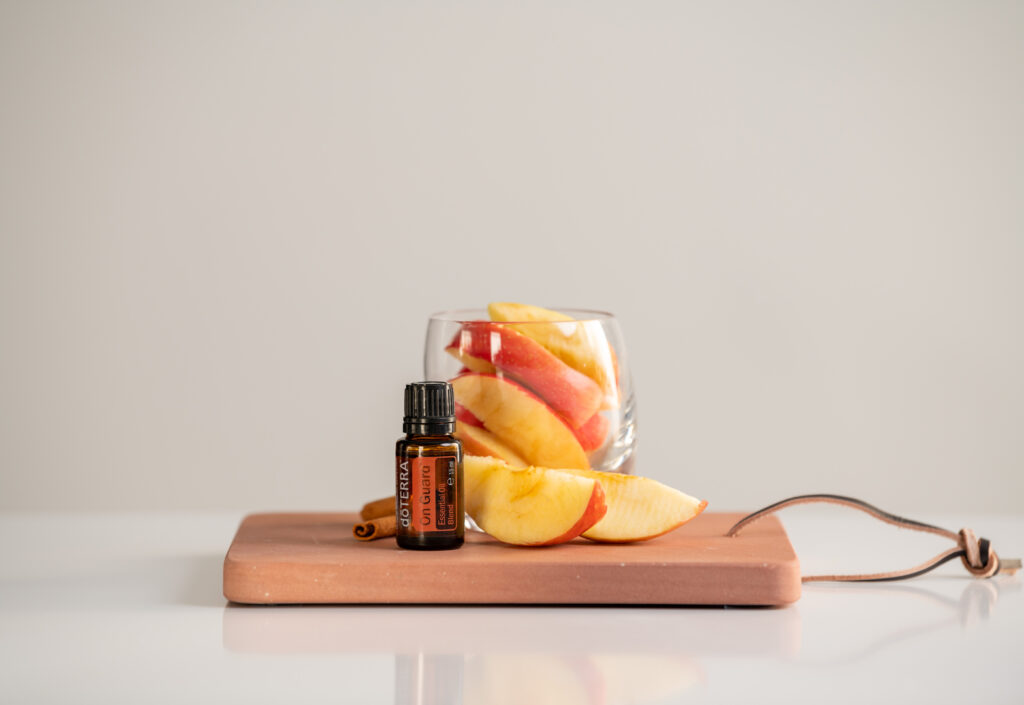 Buteleczka olejku On Guard doTERRA na drewnianej podstawce – naturalna profilaktyka odporności.