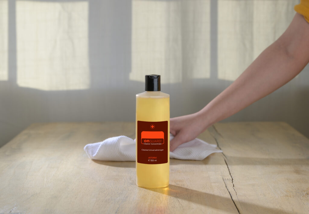 Koncentrat do czyszczenia On Guard doTERRA obok połówki pomarańczy na blacie kuchennym