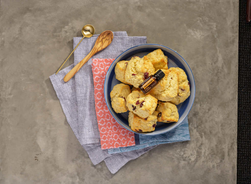 Buteleczka olejku Wild Orange dōTERRA 15ml na kruchych ciasteczkach z cukrem pudrem.