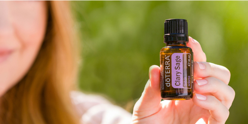 Buteleczka z olejkiem z szałwii muszkatołowej dōTERRA na naturalnym tle – olejek wspierający równowagę i potliwość w upał.